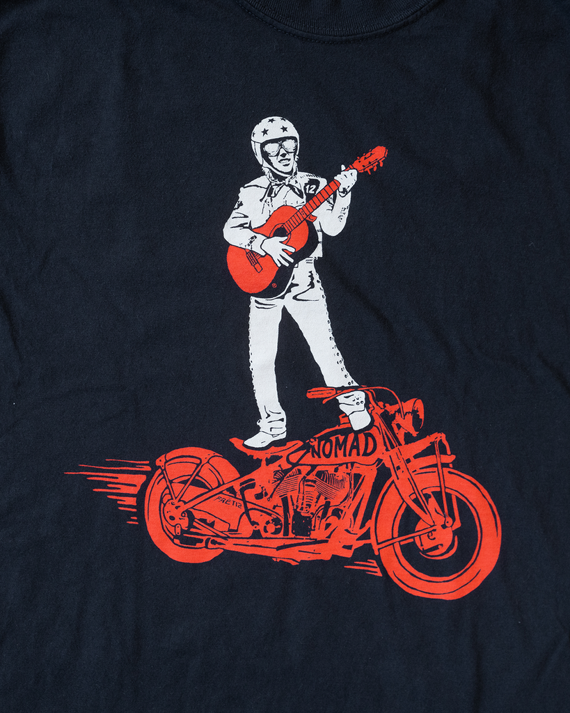 Black FRET12 Mariachi Rider Tee showcasing a bold graphic of the legendary Mariachi Rider standing on a motorcycle, strumming a guitar, set against a clean, minimal backdrop.